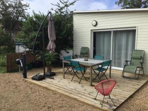 Saint-Pierre-lès-ElbeufにあるGîte du Levant 76の木製デッキ(テーブル、椅子、パラソル付)