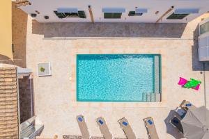 an overhead view of a swimming pool with blue chairs at Casa Carmela in Cacla D'or