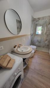 a bathroom with a sink and a washing machine at Nima in Porto Santo Stefano +11 photos