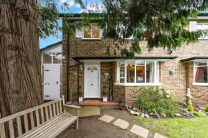 a brick house with a bench in front of it at Designer Cottage with Parking - Esher Surrey - Pass the Keys in Esher +16 photos