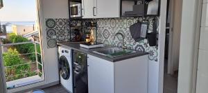 uma cozinha com pia e máquina de lavar em MonoMare em Avola