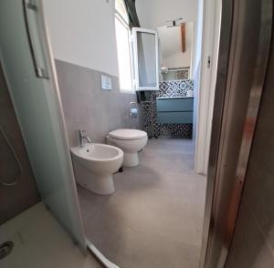 um banheiro com dois vasos sanitários e uma pia em MonoMare em Avola