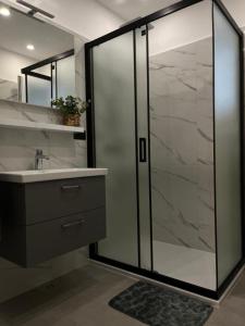 a bathroom with a glass shower and a sink at Moretino Supetar in Supetar +41 photos
