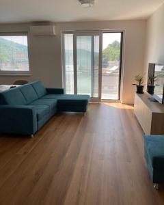 a living room with a blue couch and a television at RELAX apartmán Trenčianske Teplice in Martinske Hole