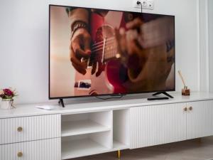 a television on a white entertainment center in a living room at Terracotta Elite Apartments in Almaty +10 photos