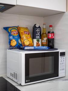 a microwave with chips and snacks on top of it at Terracotta Elite Apartments in Almaty
