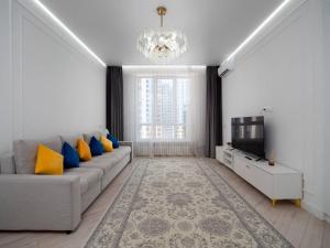a living room with a couch and a television at Terracotta Elite Apartments in Almaty