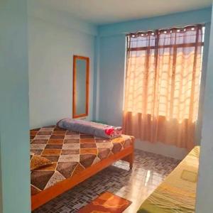 a bedroom with a bed and a window at Zinnia Homestay in Cherrapunji