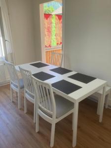 a dining room table with four chairs and a black and white at Harderblick in Interlaken +3 photos