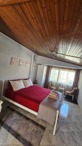 una camera con letto rosso e soffitto in legno di Με θέα το Κάστρο a Nafpaktos