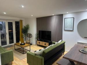 ein Wohnzimmer mit Sofa und Fernseher in der Unterkunft Elegant TWO Bedroom Apartment Amazing Views Birmingham City Centre FREE Underground Parking in Birmingham