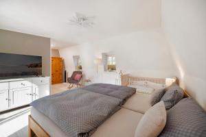 a bedroom with a bed and a flat screen tv at Haus mit 110qm und Garten 150m zum Wasser in Stralsund