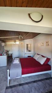 una camera da letto con un grande letto con una coperta rossa di Με θέα το Κάστρο a Nafpaktos