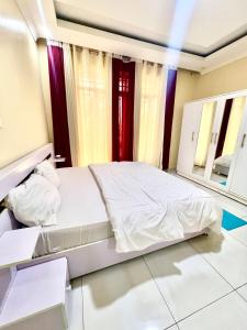 キガリにあるKigali Sky Villa Rwandaの白いベッドと2つの窓がある寝室 +21枚の写真