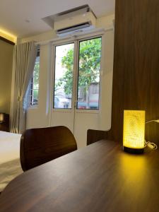 a lamp sitting on a table in a room with a window at Bamboura Home in Hanoi