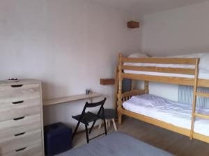 a bedroom with two bunk beds and a desk and a chair at Ty-Bougnat in Murat-le-Quaire