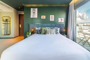 a bedroom with a large white bed and a window at Stay Hillel in Jerusalem