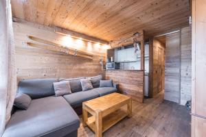 a living room with a couch and a table at Appartement 6p Au Pied Des Pistes in Val Thorens