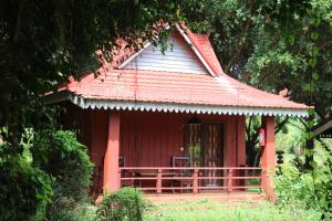 una casa rossa con tetto rosso e portico di Phum Khmer Resort a Banlung
