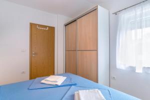 a bedroom with a blue bed and a wooden closet at Barbic - SG - MPolo in Medulin