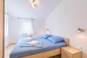 a bedroom with a blue bed with blue pillows at Barbic - SG - MPolo in Medulin