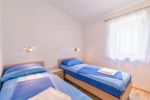 two beds in a room with a window at Barbic - SG - MPolo in Medulin