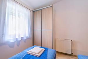 a bedroom with a bed with blue sheets and a window at Barbic - SG - MPolo in Medulin +8 photos
