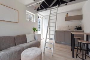ein Wohnzimmer mit einem Sofa und einer Leiter in der Unterkunft Flamingo Beach Apartments in Zandvoort