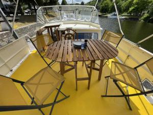 un tavolo di legno e sedie sul retro di una barca di Albatross, bateau à quai à Saint-Nicolas-des-Eaux a Saint-Nicolas