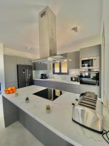 a large kitchen with a large white counter top at Villa Zina mit Infinity-Pool und Meerblick in Sitia