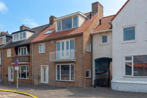 ein Backsteingebäude mit rotem Dach in der Unterkunft Flamingo Beach Apartments in Zandvoort