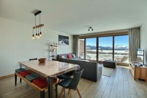 a living room with a table and a couch at ARC 1600, LE RIDGE, Appartement 10 personnes Duplex Vue Montagne - ski aux pieds - Sauna, Hammam, Piscine, Salle de salle de sport-fitness in Arc 1600