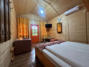 a bedroom with a bed and a couch and a tv at Luna de miere in Cinciş
