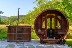 un petit bâtiment en bois avec un tonneau et un ballon de football dans l'établissement Cinija Cottage - Family Eco Retreat in Nature Park, à Kupčina