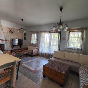 a living room with a couch and a tv at Eternal Sunset Villa #1 in Pefkohori
