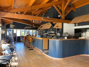 a restaurant with a bar and tables and chairs at Kabana Village in Saint-Hilaire-de-Riez