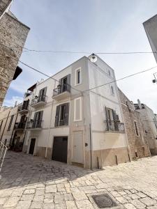 a large white building on a cobblestone street at Essenze di Puglia - Holiday Rental in Conversano