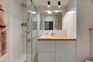 a bathroom with a sink and a shower at Blue Mandarin - Chlebova Apartments in Gdańsk +70 photos