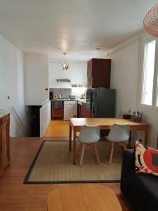 Una sala de estar y una cocina con mesa y sillas. en Damalix, en Saint-Maurice