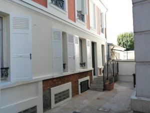 Una fachada de un edificio con puertas y escaleras blancas. en Damalix, en Saint-Maurice