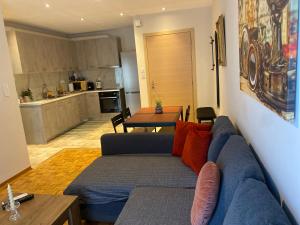 a living room with a blue couch and a kitchen at Lydia's City View Apartment in Ioannina