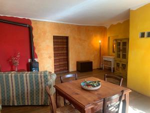 a living room with a table and a couch at Ina Maka - Appartamento con giardino immerso nel verde in Mengara