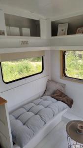a small room with a couch in a tiny house at Heller Wohnwagen auf Tierschutz Landhof inmitten der Natur in Selmsdorf