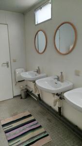 a bathroom with two sinks and two mirrors at Heller Wohnwagen auf Tierschutz Landhof inmitten der Natur in Selmsdorf