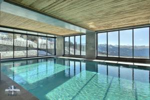 a swimming pool with a view of the mountains at ARC 1600, LE RIDGE, Appartement 10 personnes Duplex Vue Montagne - ski aux pieds - Sauna, Hammam, Piscine, Salle de salle de sport-fitness in Arc 1600