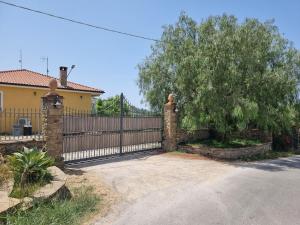 einen Zaun mit einem Baum vor einem Haus in der Unterkunft Villa Dei Santi, Azzurro in Santa Maria di Castellabate