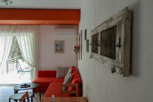 a living room with a red couch and a table at Eirini's apartment in Kanali