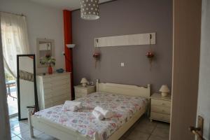 a bedroom with a bed and two dressers and a mirror at Eirini's apartment in Kanali