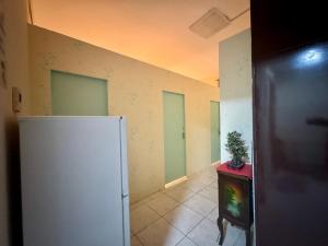 an empty room with a refrigerator and a plant on a table at Backpacker's Bed - No Parking in Abu Dhabi