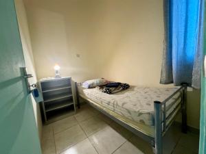 a small bed in a small room with a light at Backpacker's Bed - No Parking in Abu Dhabi +5 photos